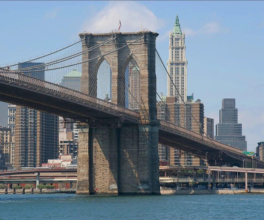 Brooklyn Bridge Over East River Brooklyn Bridge spanning East River with New York City skyline in the background, showcasing iconic architecture and urban landscape.