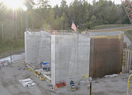 Concrete structure with scaffolding and an American flag at a construction site.