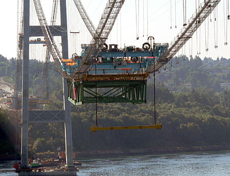 Bridge Construction Equipment Over Water Construction equipment suspended from a bridge structure over a body of water.