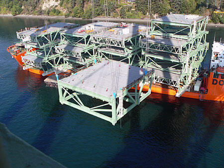 Large Industrial Shipping Platform Large industrial shipping platform being loaded onto a cargo ship, showcasing heavy machinery and construction elements.