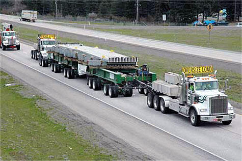 Oversized Load Transport Trucks A convoy of trucks transporting oversized loads on a highway, showcasing heavy-duty vehicles and large cargo.