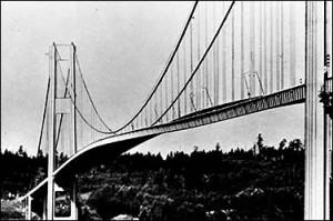 Black and white image of a suspension bridge with cables and towers.