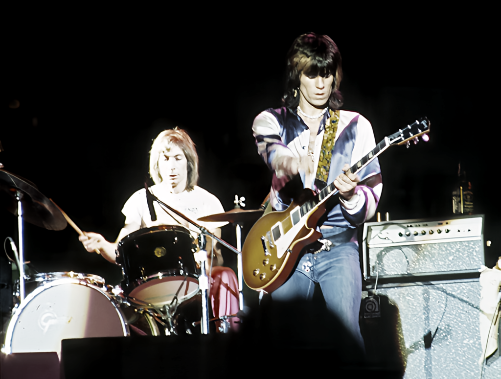 Rolling Stones performing live on stage with a Charlie Watts drummer and Keith Richards guitarist, showcasing musical instruments and energetic atmosphere.